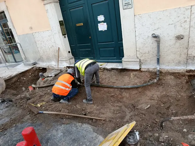 Due tecnici di Tutto Condotte al lavoro su un allaccio di servizi interrati in centro storico