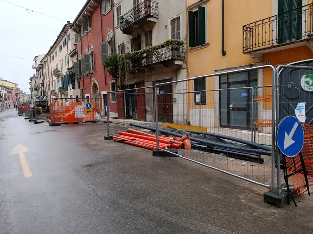Cantiere recintato per la posa di sottoservizi lungo una via del centro storico